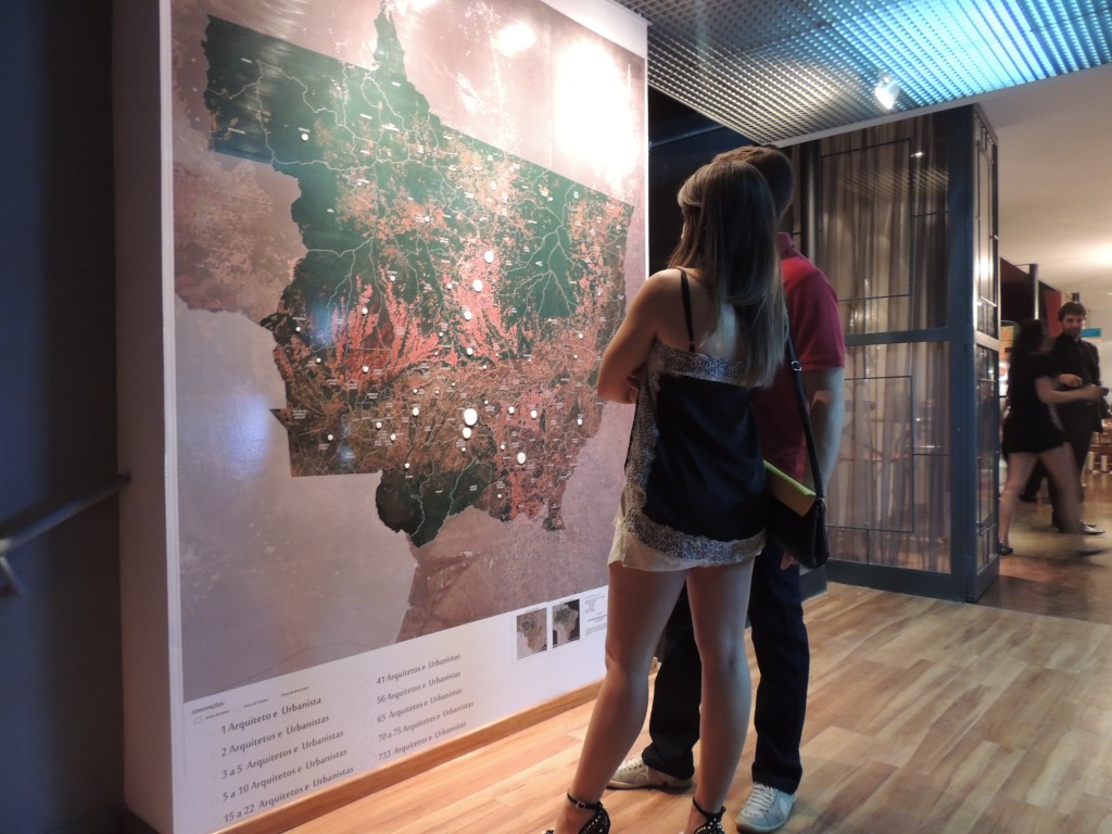 Visitantes da Mostra Morar Mais por Menos observando o mapa que identifica os profissionais do Estado.